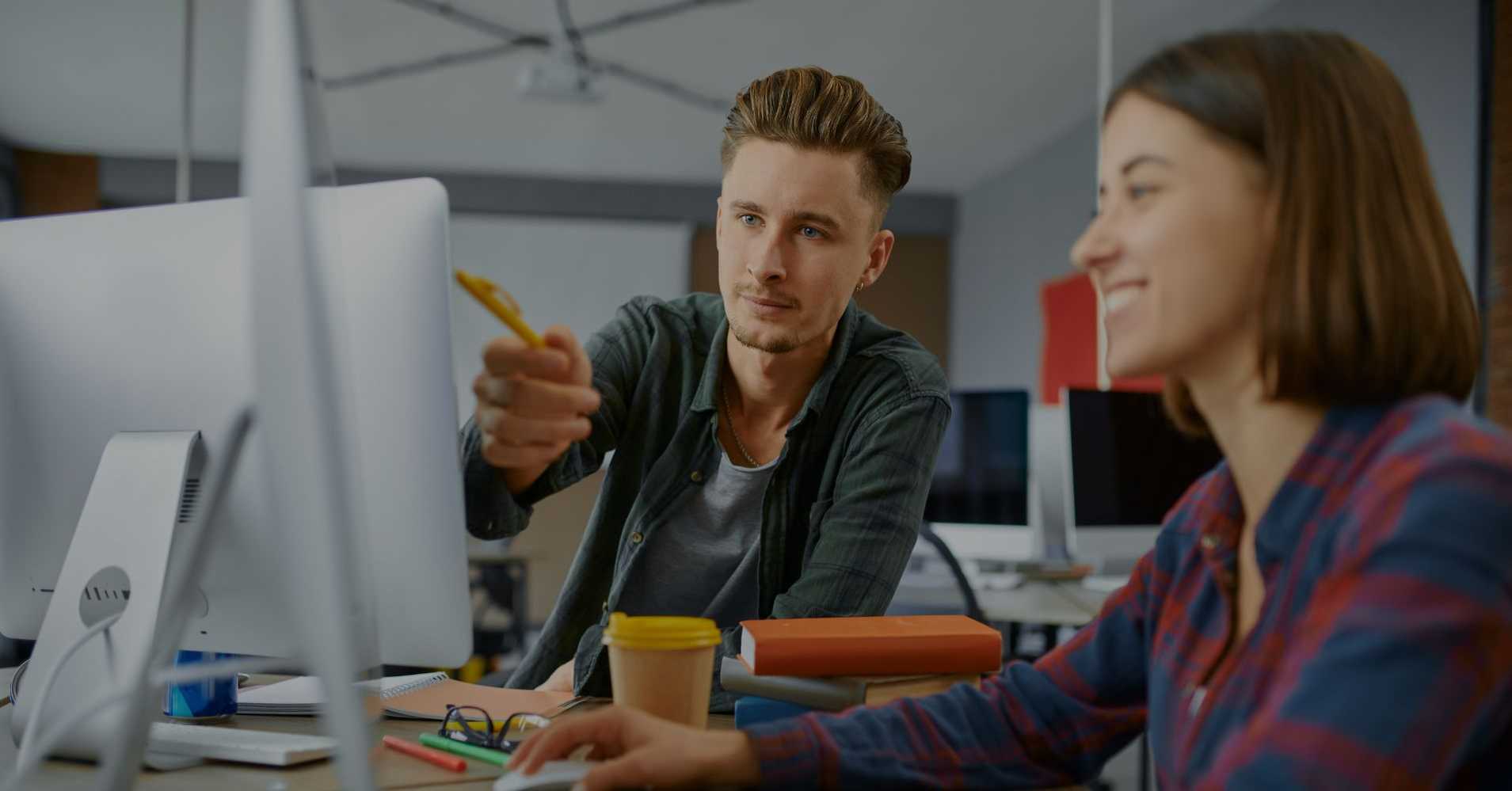 man and woman looking at computer screen